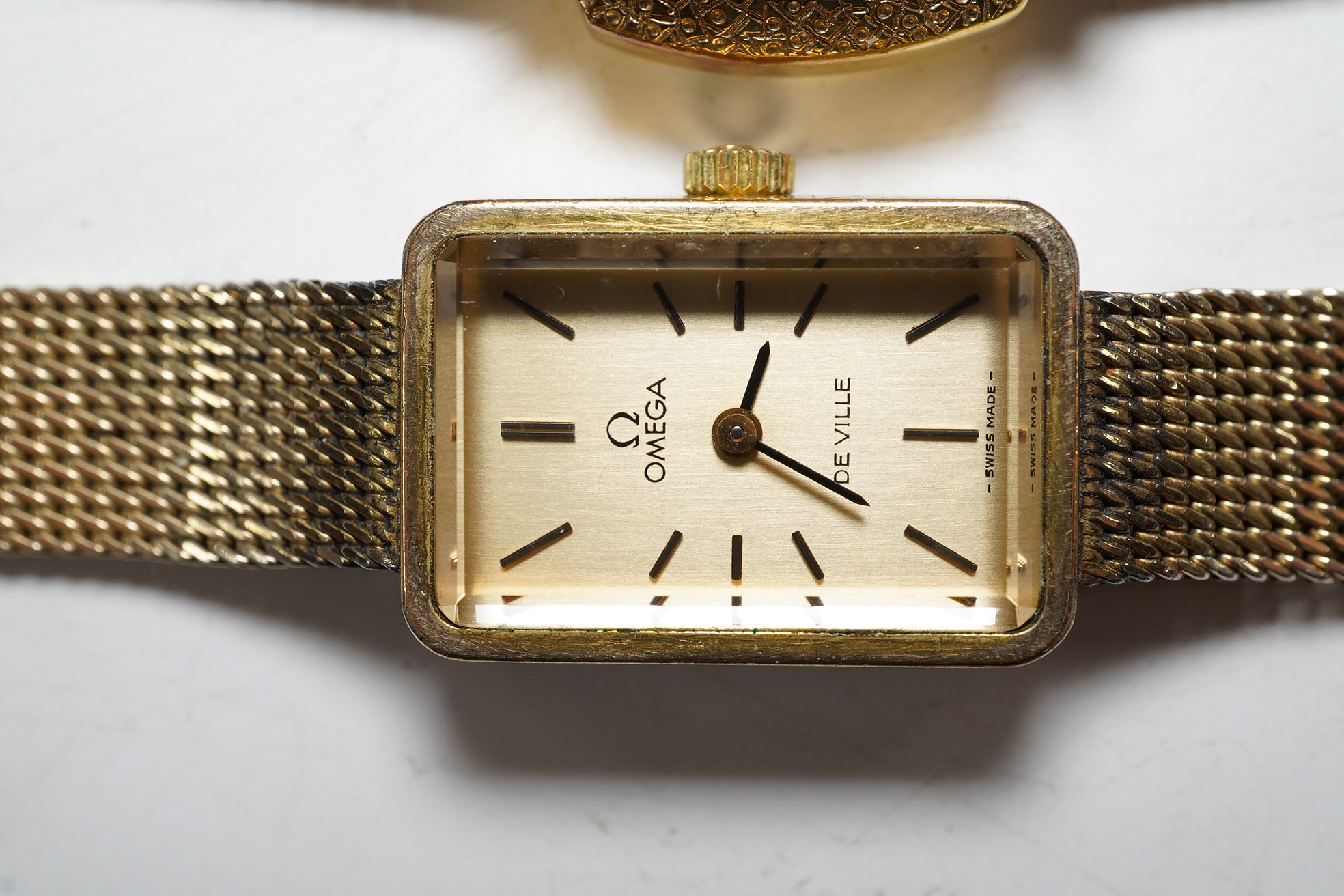 A ladies stylish Baume Mercier 18ct gold wrist watch, in original green leather case, and two gold plated wrist watches by Omega and Bucherer. Condition - Baume Mercier movement not going, later strap with gold plated bu